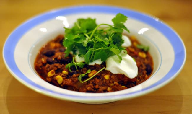 Plat de chili avec coriandre et crême fraîche.