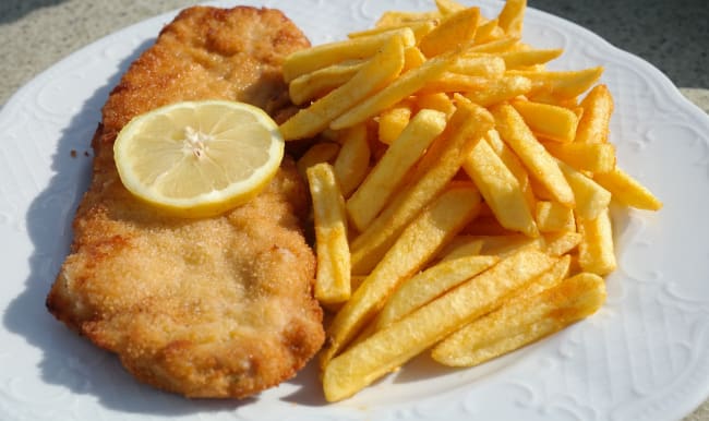 Filet de poisson pané sur assiette blanche avec frites