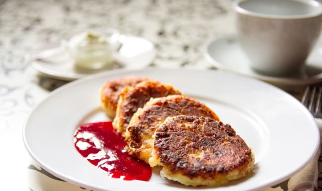 Syrniki accompagnés de confiture aux fruits rouges.