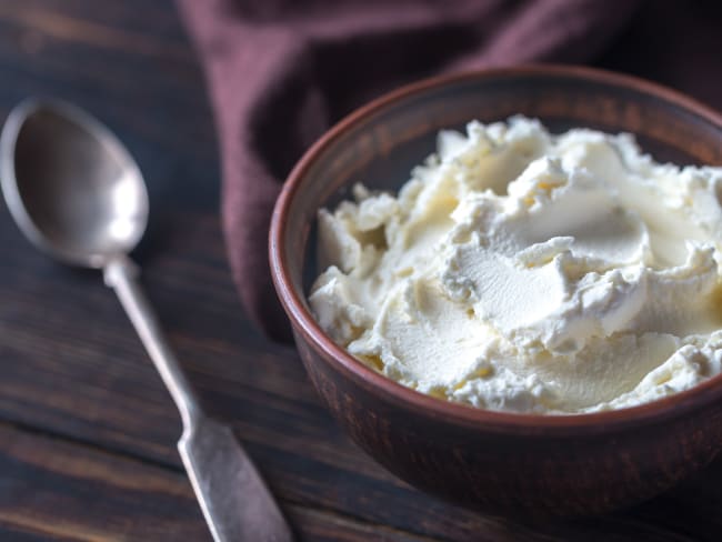 Mascarpone dans un bol marron et cuiller