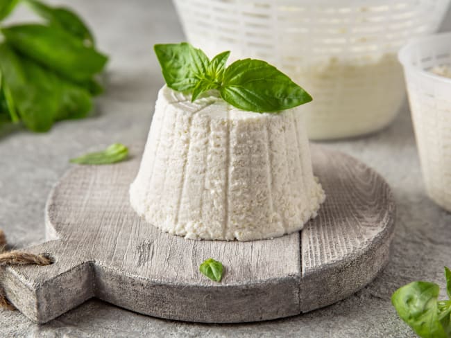 Ricotta maison posée sur planche et basilic