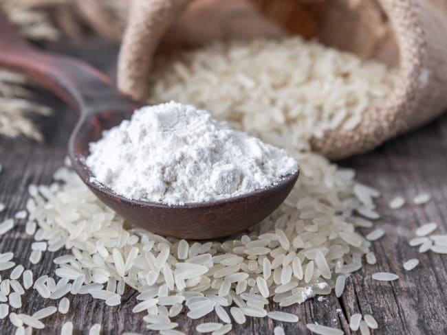 Farine de riz blanc dans une cuiller en bois