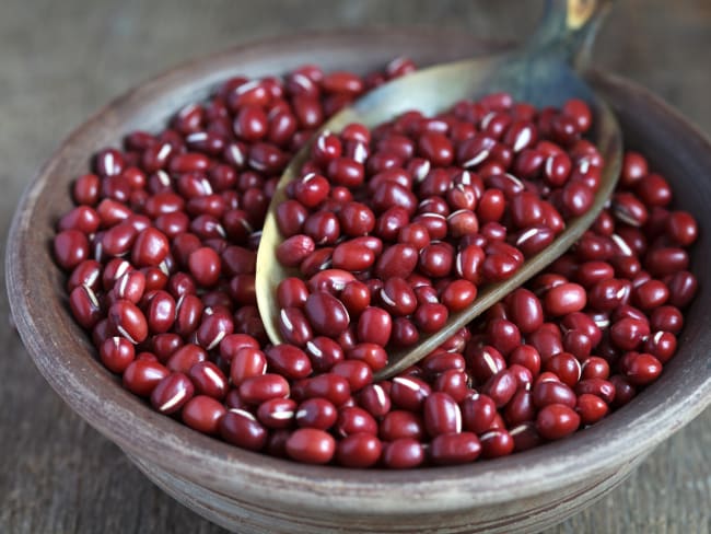 Haricots azuki secs dans un bol en argile sur une table en bois