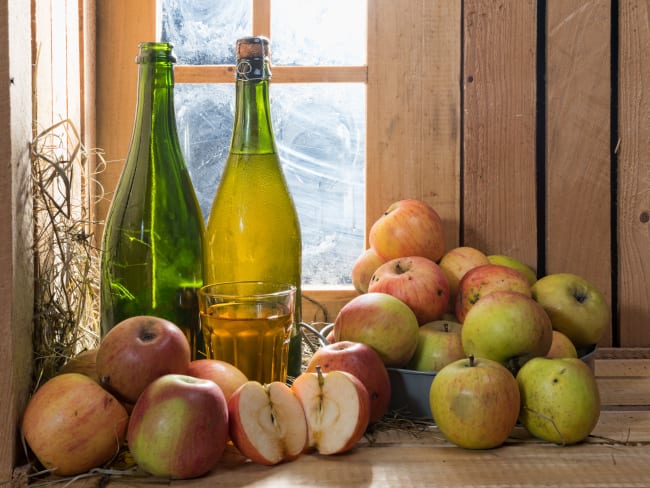 Bouteilles, verre de cidre et pommes