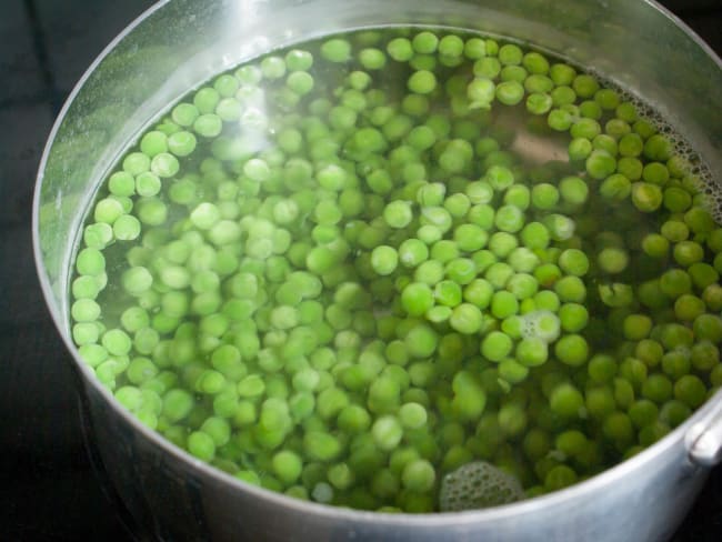 Casseroles de petits pois dans l'eau frémissante.