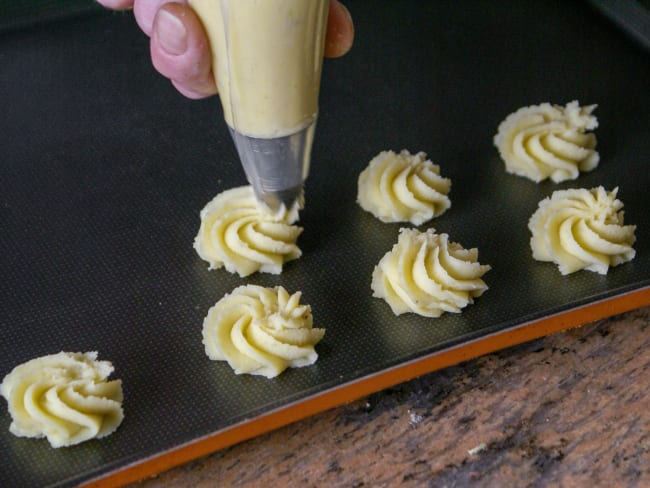 Pommes duchesse sur plaque à pâtisserie.