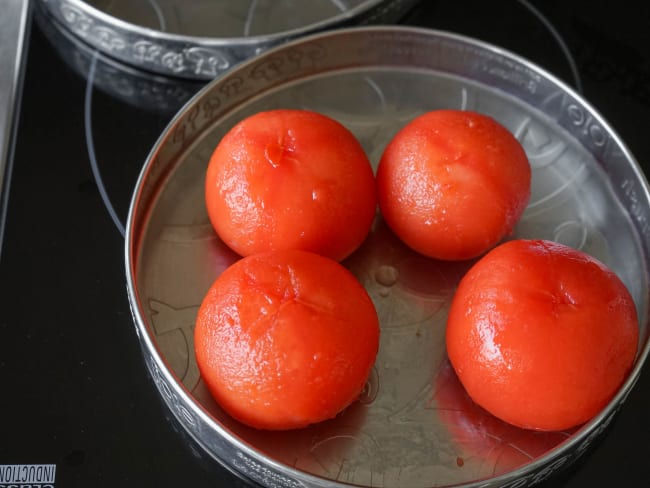 Tomates fraîchement mondées dans un plateau en fer blanc.