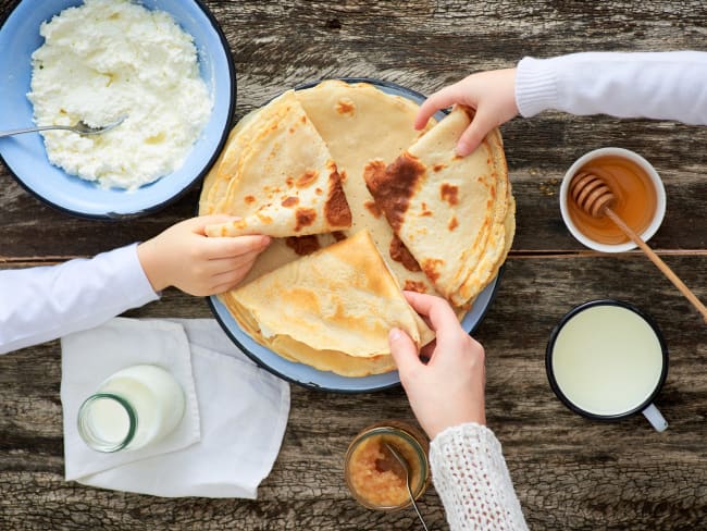 Petites mains saisissant des crêpes pliés pour un goûter