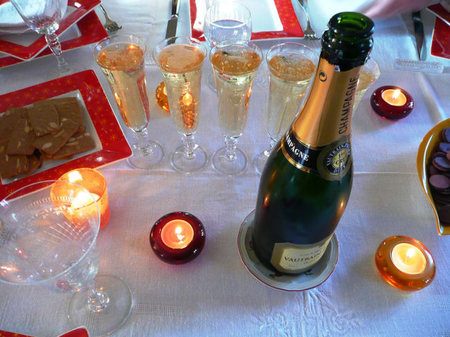 Coupes, bouteille de champagne et lumignons sur une table de fête