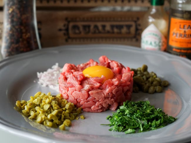 Assiette de tartare non préparé avec oeuf et condiments