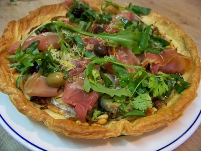 Tarte feuilletée aux olives niçoises, fromage de chèvre, confit d'oignons et jambon Serrano au miel de châtaigne