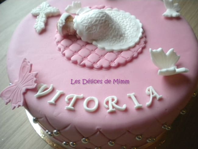 Un gâteau de baptême rose avec des papillons