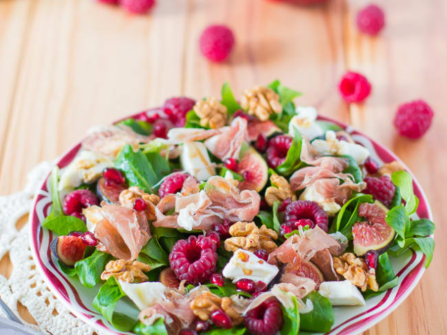 Salade de mâche, noix, framboises, crottin de chèvre, grenade et figues aux lamelles de jambon de Parme