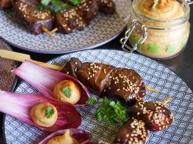 Brochettes de boeuf teriyaki et feuilles d'endives sur assiette bleue