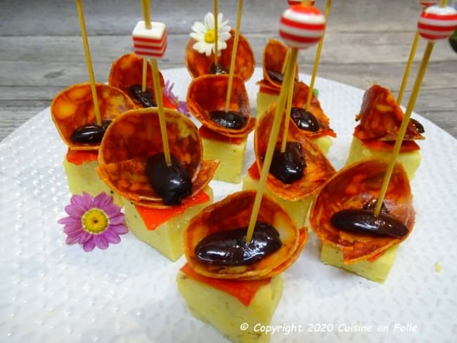 Tapas de polenta à l'origan, chorizo de Bellotta, piquillos et olives de Kalamata en amuse-bouche