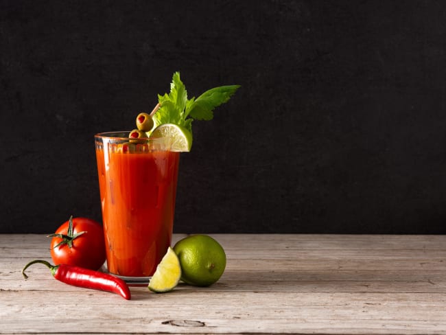 Cocktail Bloody Mary dans un verre posé sur une table en bois