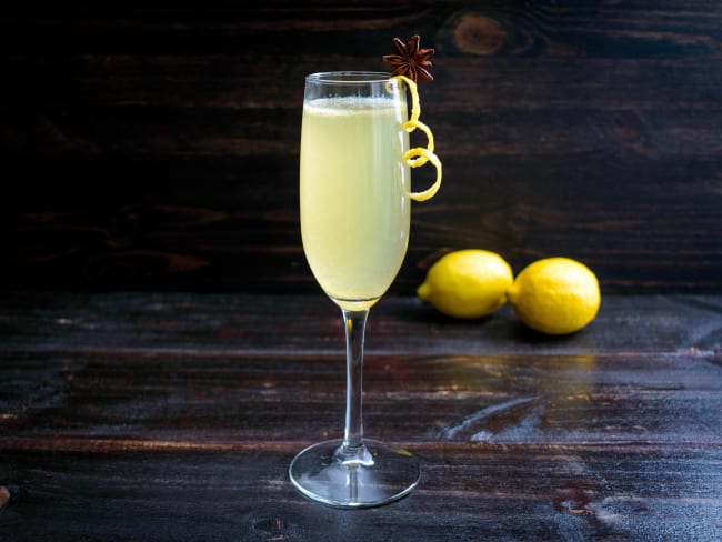 Un verre de cocktail French 75 et des citrons