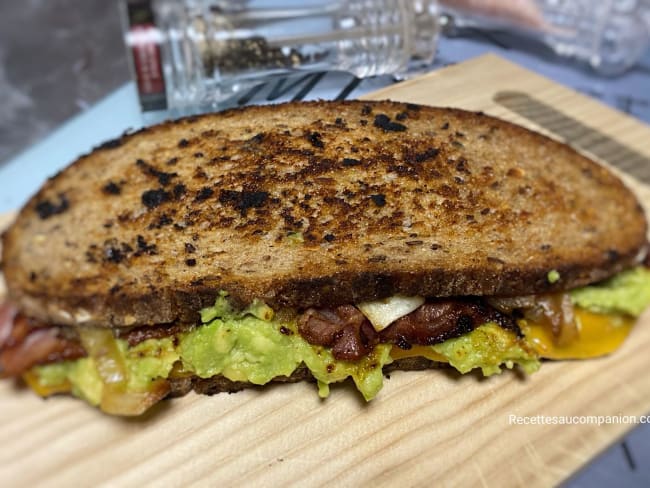 Toast de pain de campagne à l’avocat, oignons frits, poitrine fumée et cheddar coulant