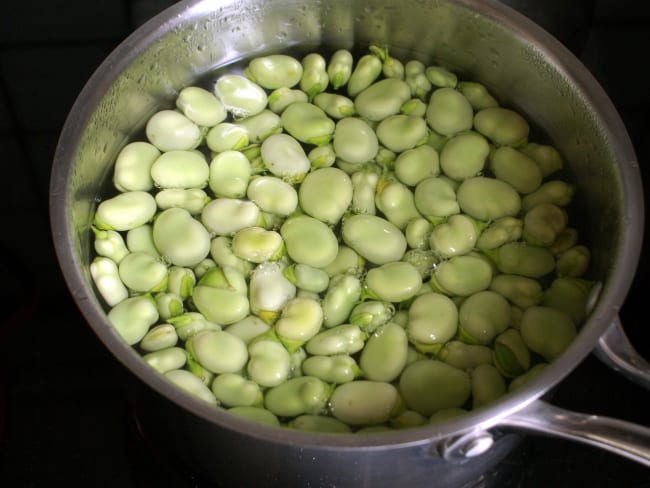 Fèves fraîches dans une casserole d'eau bouillante