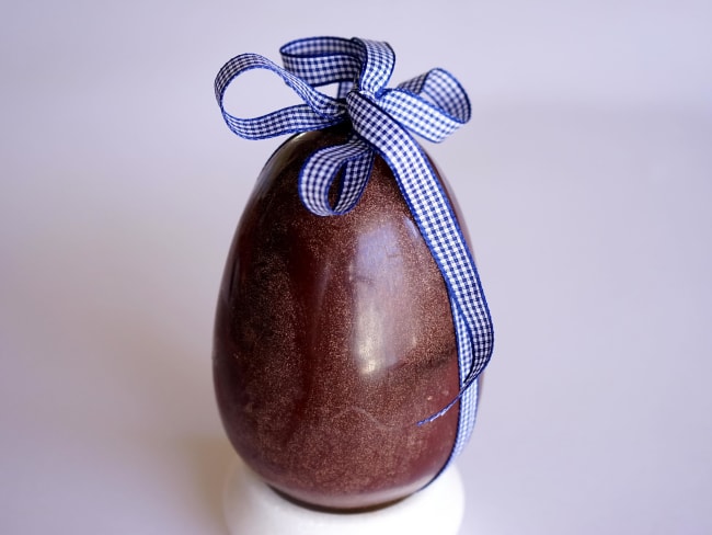 Gros oeuf en chocolat pour Pâques et ruban bleu