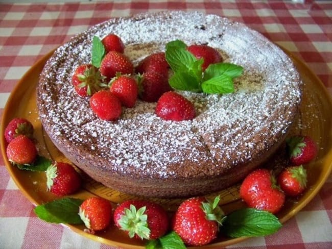 Gâteau au chocolat fondant aux noisettes, petites fraises charlottes et compotée de prunes