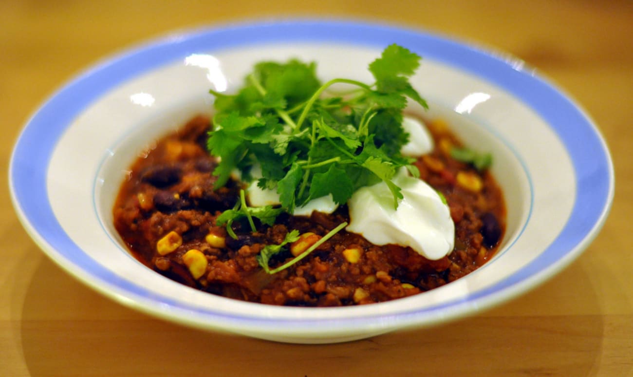 Plat de chili avec coriandre et crême fraîche.