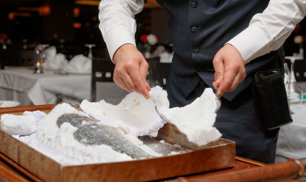 Service d'un poisson cuit en croûte de sel.