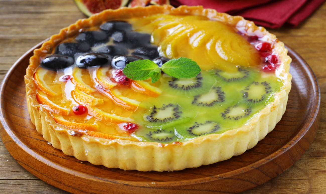 Tarte aux fruits variés sur assiette en bois