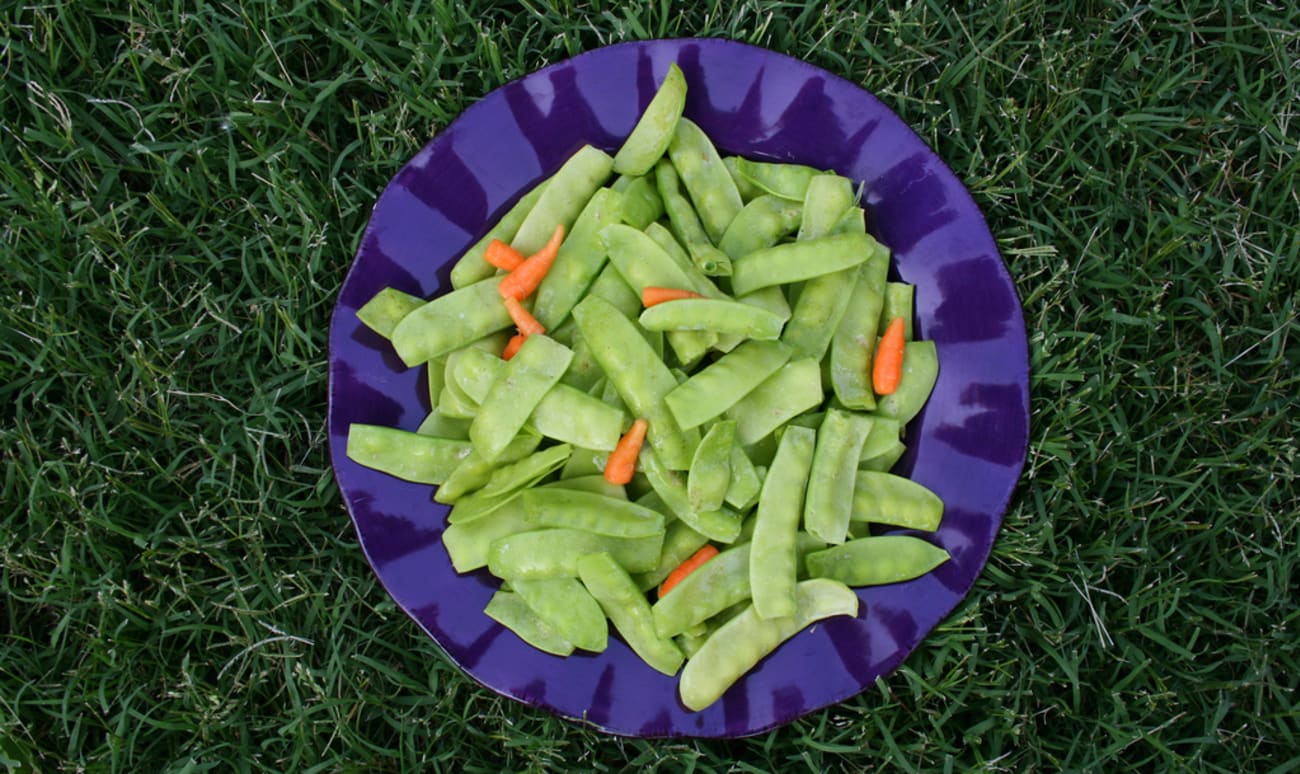 Assiette de pois gourmands et jeunes carottes