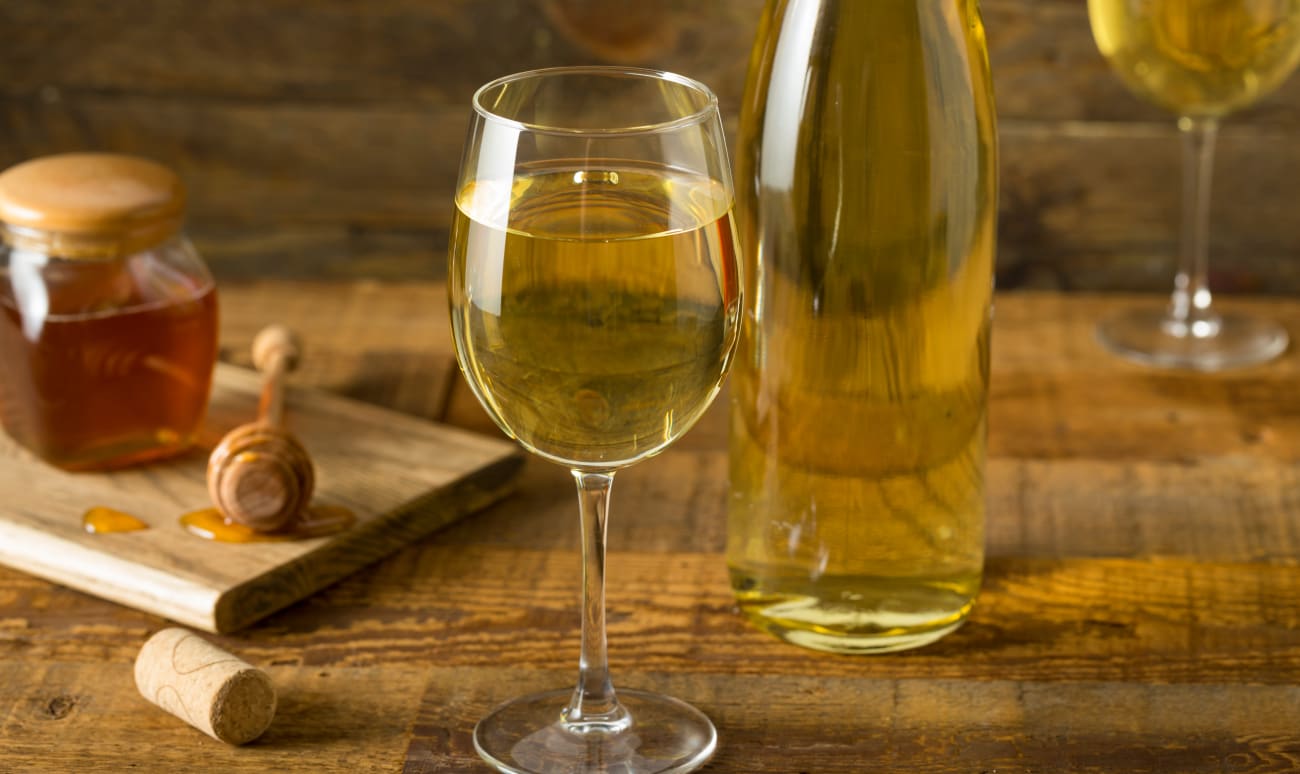 Verres et bouteille d'hydromel sur table en bois