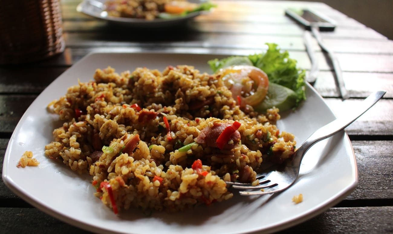 Assiette de nasi goreng, rondelles de tomate et salade verte