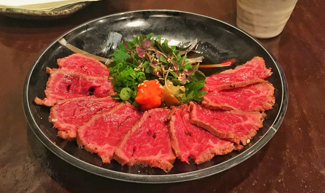 Tataki de boeuf Wagyu sur assiette noire