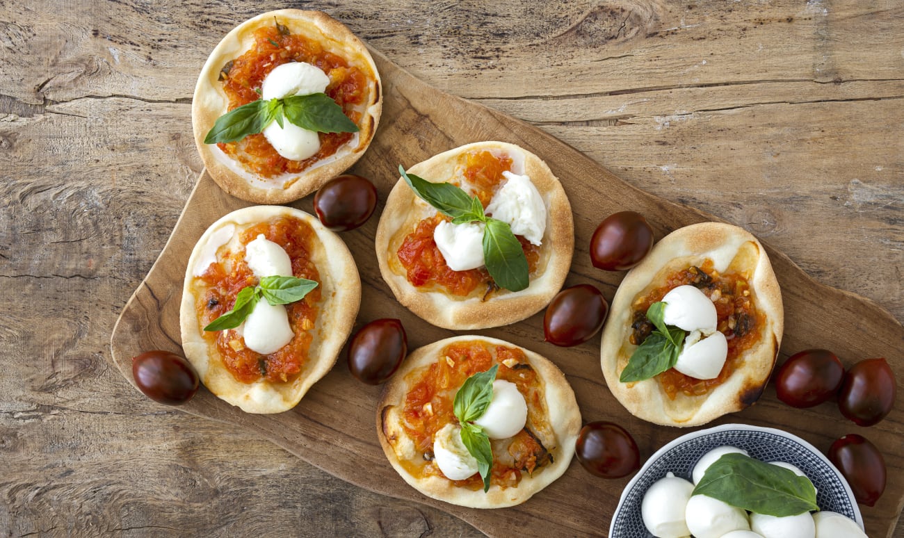 Mini pizzas margarita sur planche de bois