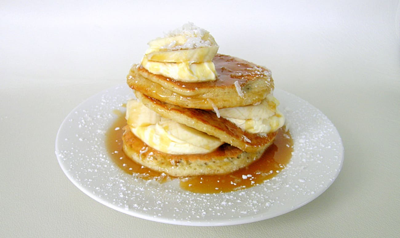 Assiette de pancakes coco avec bananes et sauce caramel 