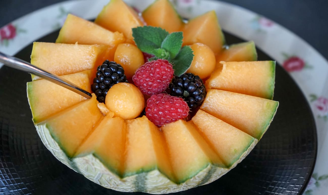 Salade de fruits servie dans un melon découpé en dents de loup