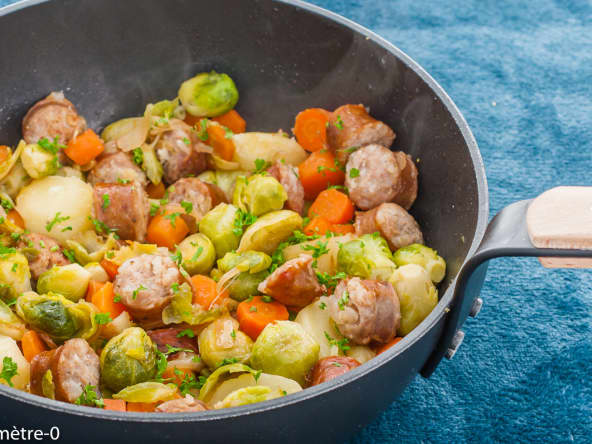 Sauté de légumes d'hiver, choux de bruxelles, carottes, pommes de terre et saucisses fumées