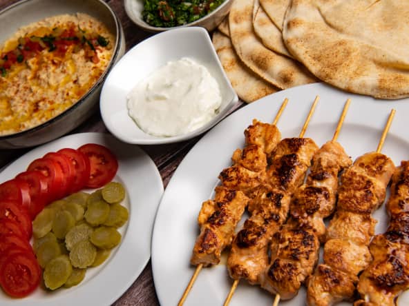 Brochettes de poulet chich taouk, sauce à l'ail, taboulé et houmous