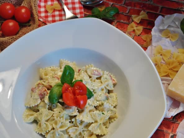 Assiette de farfalle, crème fraîche et tomates.
