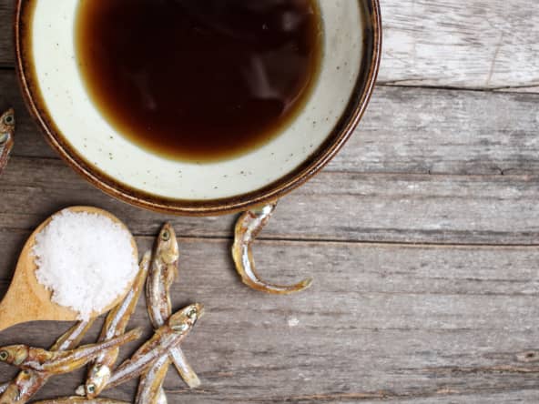 Sauce de poisson dans un bol, poissons séchés et gros sel