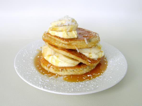 Assiette de pancakes coco avec bananes et sauce caramel 