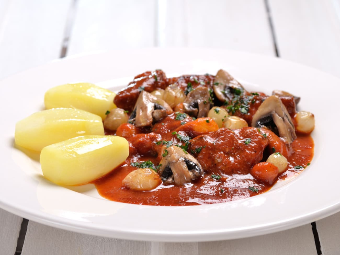 Veau Marengo et pommes tournées sur assiette blanche