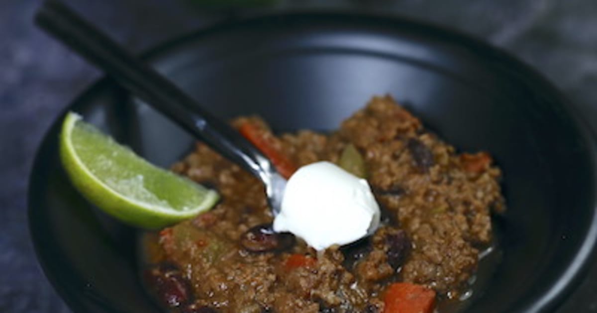 Chili con carne accompagné de crème fraîche et citron vert