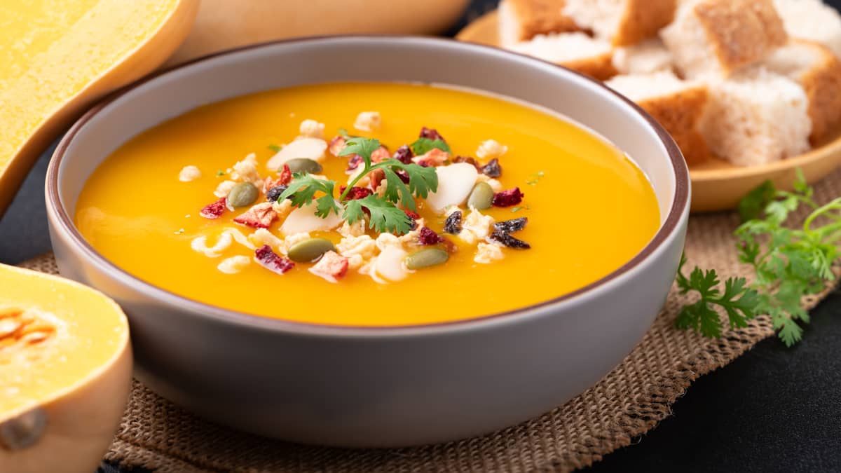 Soupe de courge musquée et de potiron avec granola dans un bol