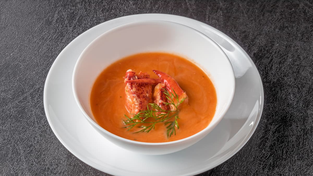 Bisque de homard servie dans une assiette blanche