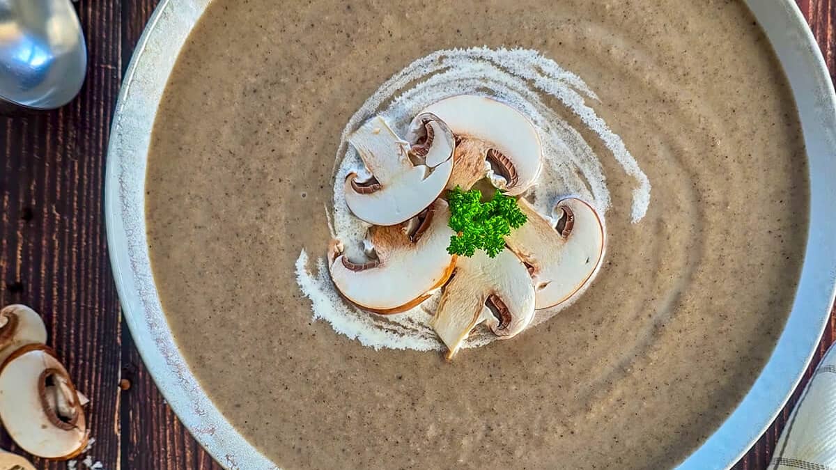 Assiette de velouté de champignons de Paris, avec quelques champignons émincés