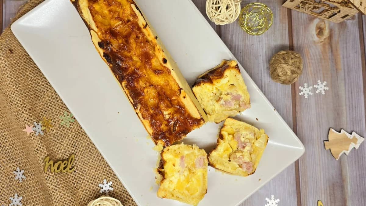 Belle quiche au brie et à la pomme dans un plat blanc posé sur une table de fête