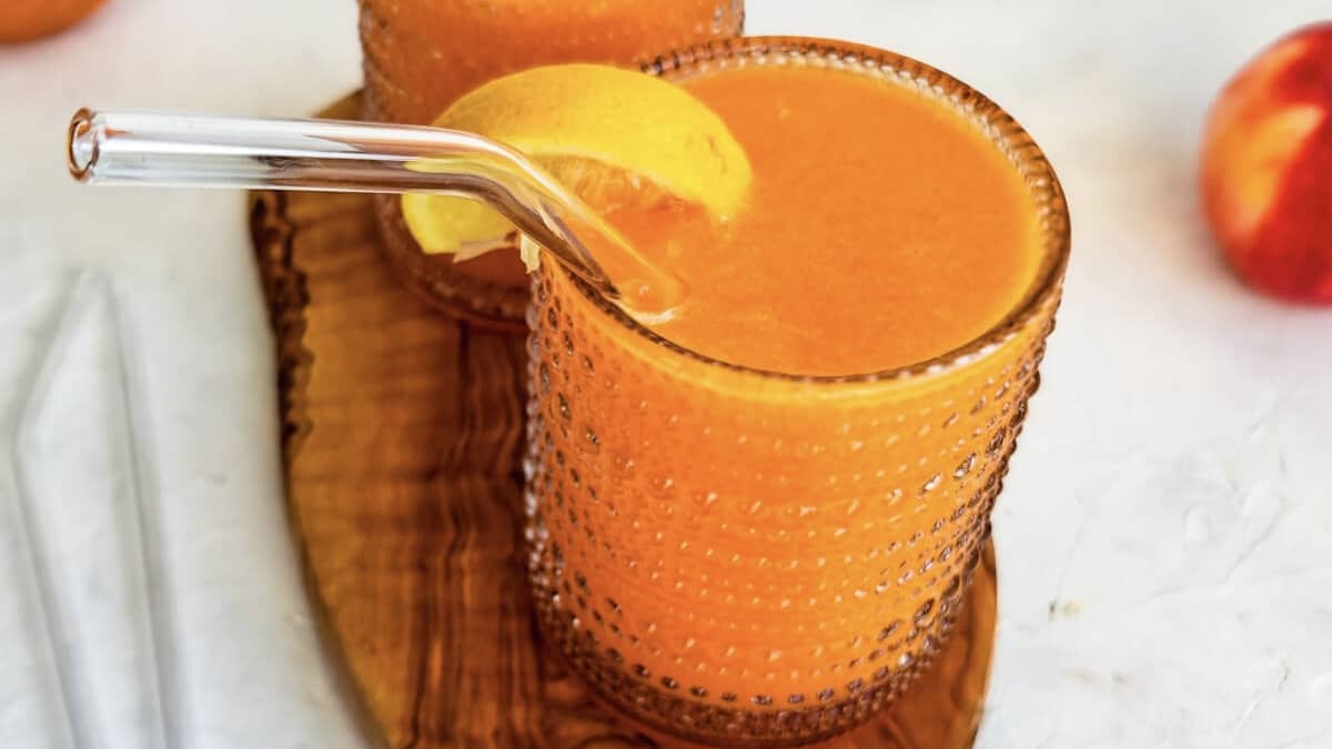 Verre de jus de carotte orange gingembre décoré d'une rondelle de citron