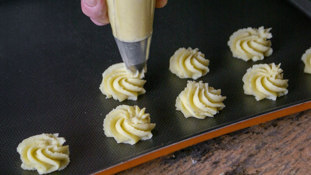 Pommes duchesse sur plaque à pâtisserie.