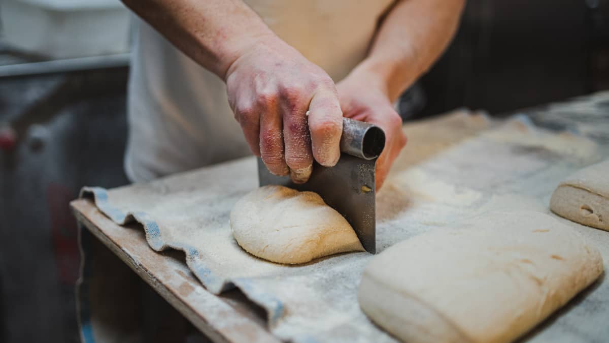 Façonnage de la pâte à la main dans le fournil d'Au Four de Jeanne