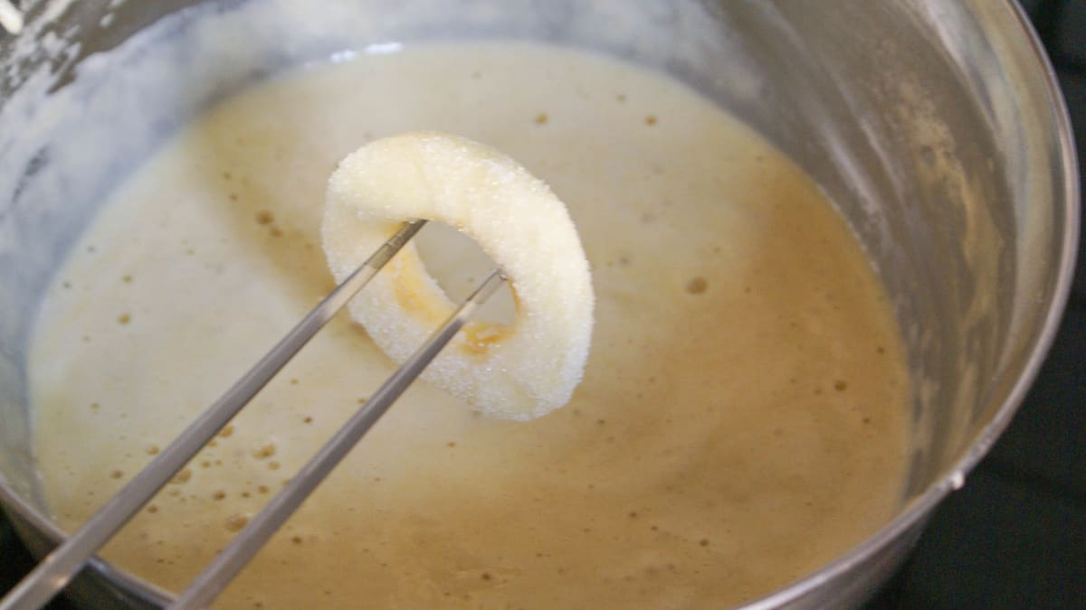 Tranche de pomme trempée dans la pâte à beignet.